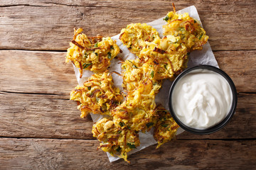 Homemade Indian fried onion bhaji with yogurt close-up. Horizontal top view