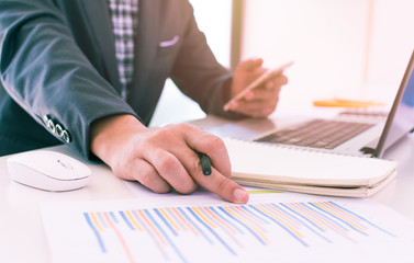 accounting,financial,close up of business man hand working on laptop computer with business graph information diagram on wooden desk as concept,vintage,selective focus