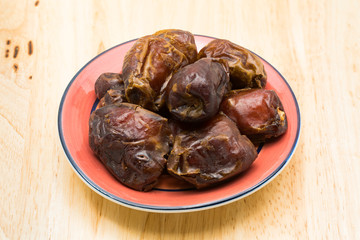 Dried dates fruit in a red plate