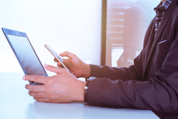 Business man, technology and internet concept, Close up of male hands with smartphone. Online shopping or banking concept, credit ,debit. Businessman using smart phone with conputer laptop on desk.