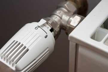 Heating controler on a white radiator close up macro shot.