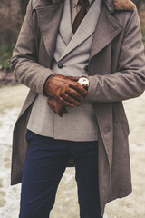 Handsome elegant man in the park wear suit and coat.