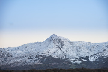 Naklejka na ściany i meble Beautiful Winter sunrise landscape image of Mount Snowdon and other peaks in Snowdonia National Park