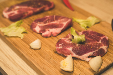 Raw spare ribs herbs spices on a wooden cutting board with knife.