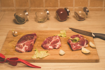 Raw spare ribs herbs spices on a wooden cutting board with knife.