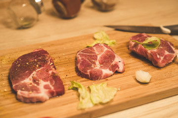 Raw spare ribs herbs spices on a wooden cutting board with knife.