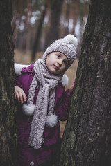 Little girl in the pine forest in autumn