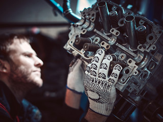 Fototapeta na wymiar Closeup repair of an opposing engine by an auto mechanic.