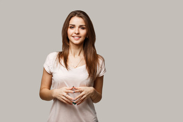 Fototapeta premium Close up portrait of young cheerful beautiful girl with dark hair in casual shirt smiling and looking in camera.