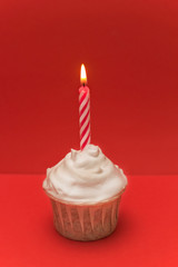cute cupcake  with burned candle red  background