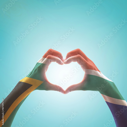 South Africa flag on woman hands in heart shape isolated on mint background for national unity, union, love and reconciliation concept.