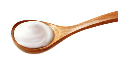 cream sour in wooden spoon