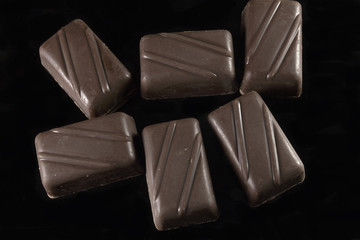 Slices of chocolate isolated on dark background.