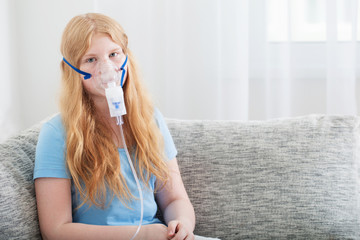teenager girl doing inhalation indoor
