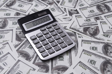 calculator on a background of dollar bills. business. incomes, expenses.