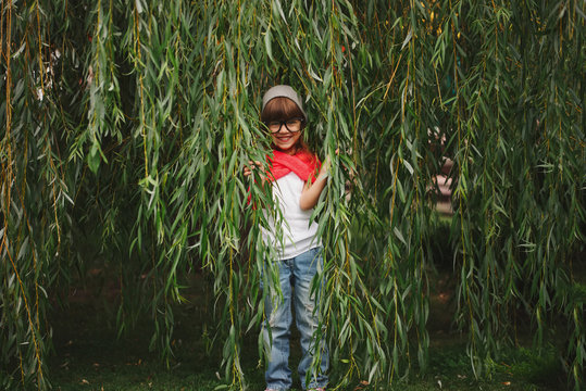 little girl hiding in the willow foliage