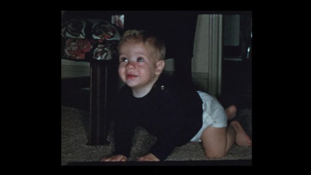 1953 Happy blond baby boy crawls furiously