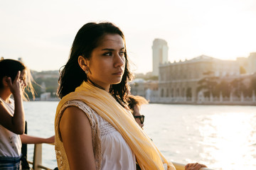 A girl looks at Istanbul at sunset during a tour of bosfor - obrazy, fototapety, plakaty