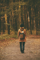 Fototapeta premium Young stylish hipster girl standing in the autumn park and smiling, retro vintage image