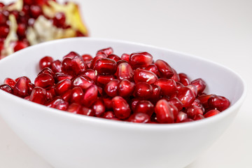Pomegranate seeds close up on white background