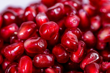 Pomegranate seeds close up on white background