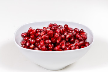 Pomegranate seeds close up on white background