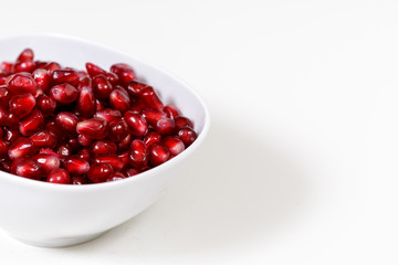 Pomegranate seeds close up on white background