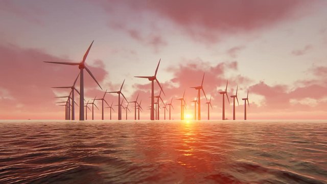 Wind turbine power generators silhouettes at ocean at sunset.
