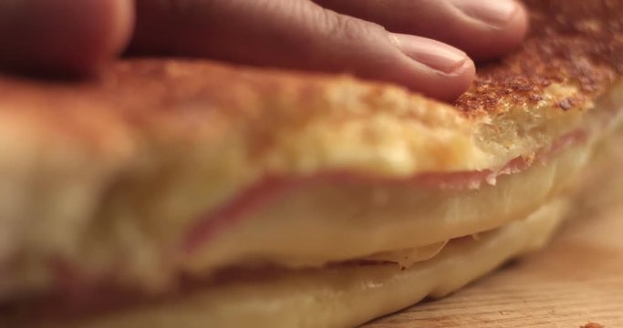 closeup of handmade delicious sandwich with ham and cheese. cutting it and press to show cheese texture. breackfast sandwich