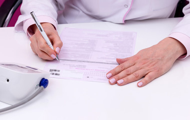 doctor writing documents at desk in clinics office
