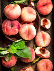 Ripe peaches on a wooden tray.