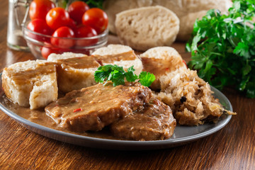 Pork loin in gravy with bread dumplings and sauerkraut