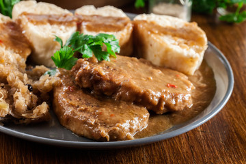 Pork loin in gravy with bread dumplings and sauerkraut