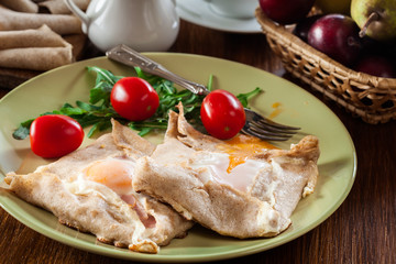 Crepes with ham, cheese and poached egg on a plate