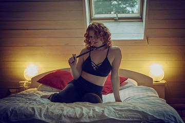 Young redheaded woman with sexy leather neck choker