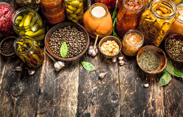 Different preserved vegetables from vegetables and mushrooms in glass jars.