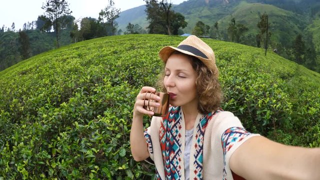 Travel Technology And Adventure Concept. Woman Taking Selfie At Tea Plantation Drinking Tea. 4K. 