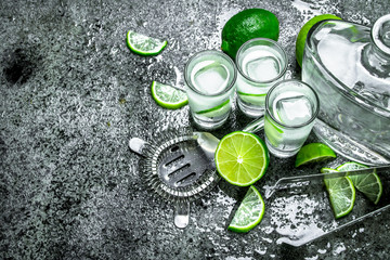 Vodka with pieces of lime and ice cubes.