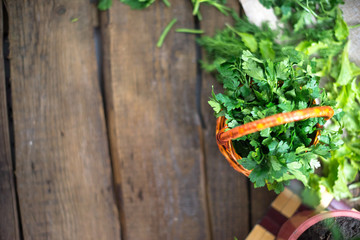 Parsley in a basket on a wooden background.