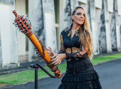 Girl playing sasando, traditional indonesian music instrument