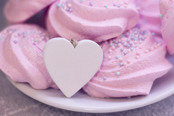 Pink marshmallows and wooden heart