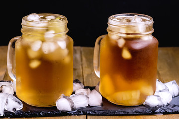 Summer Cold Ice Tea with Citrus and Ice Cube in Glass Jar Wooden Background Close Up Cold Summer Beverage