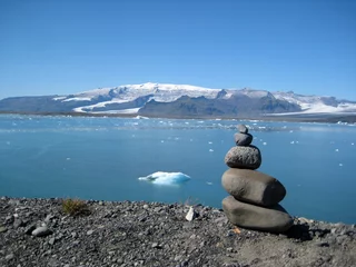 Blick über einen Steinmann auf die Gletscherlagune Jökulsárlón im Osten Islands © Andrea