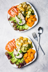 Healthy meal, steamed fish, roasted vegetables, fresh tomato salad. Top view, copy space. 