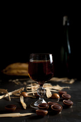 glasses with wine, chocolate and fruit on a dark background