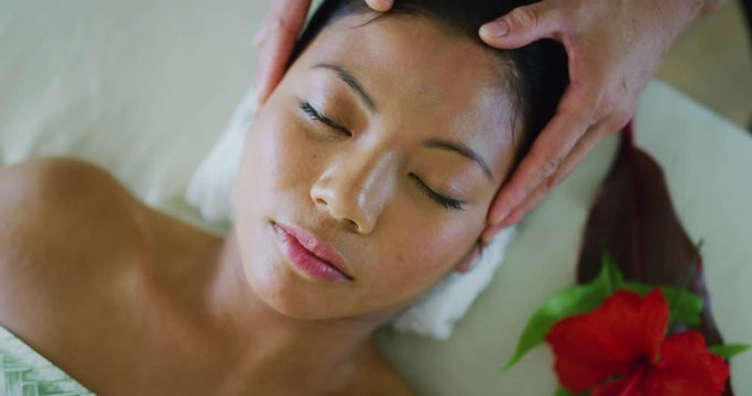 Woman relaxing receiving facial treatment at the spa