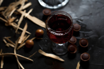 glasses with wine, chocolate and fruit on a dark background