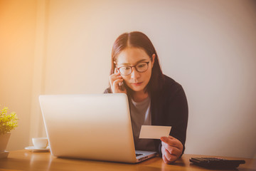 Women are happily playing the phone in the office.