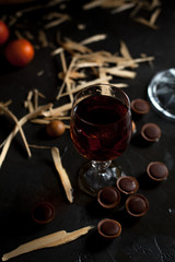 glasses with wine, chocolate and fruit on a dark background