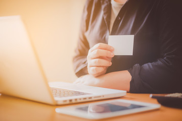 Young woman holding credit card and using laptop computer. Online shopping concept